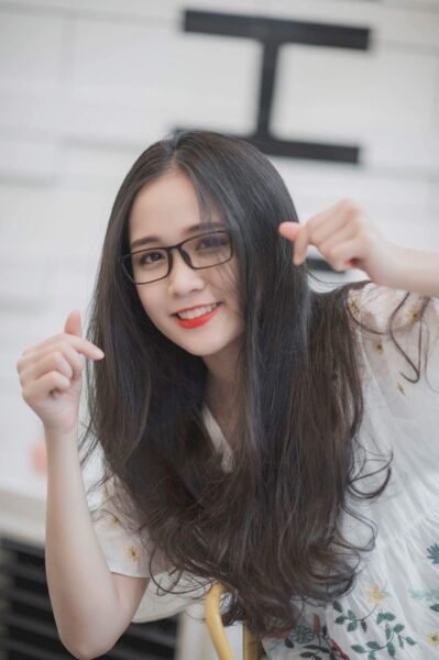 Foto eines süßen Mädchens mit langen Haaren, das eine Brille trägt