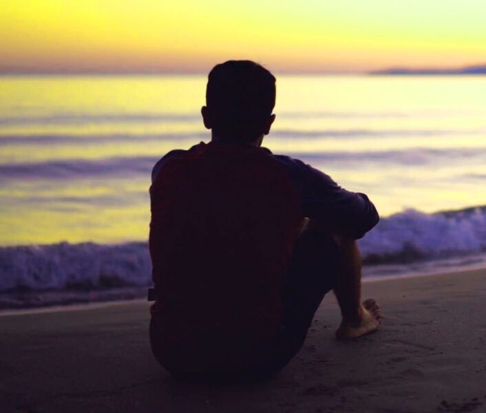 Ảnh sad boy ngồi bên bờ biển