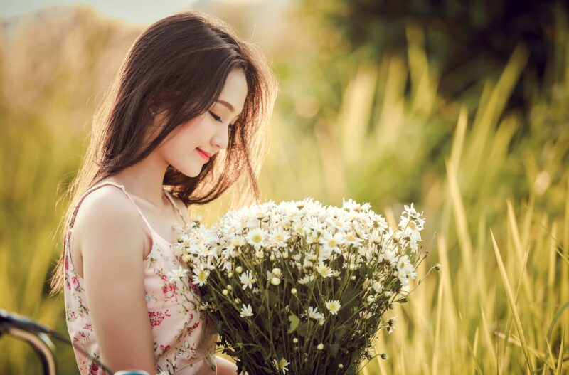 Hình ảnh cô gái cầm hoa trong cánh đồng