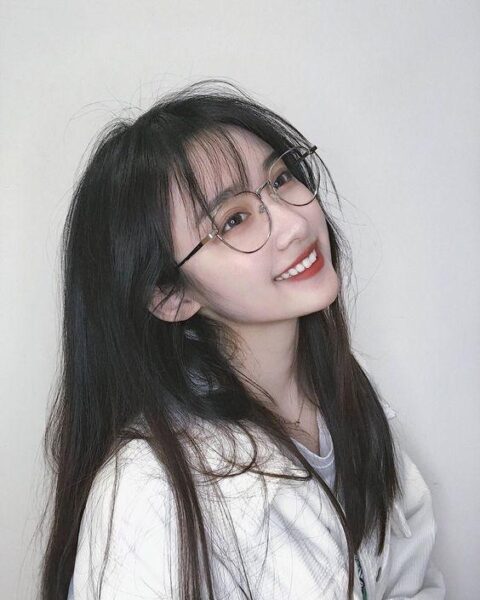 Bild eines schönen Mädchens mit langen Haaren, das eine Brille mit einem strahlenden Lächeln trägt