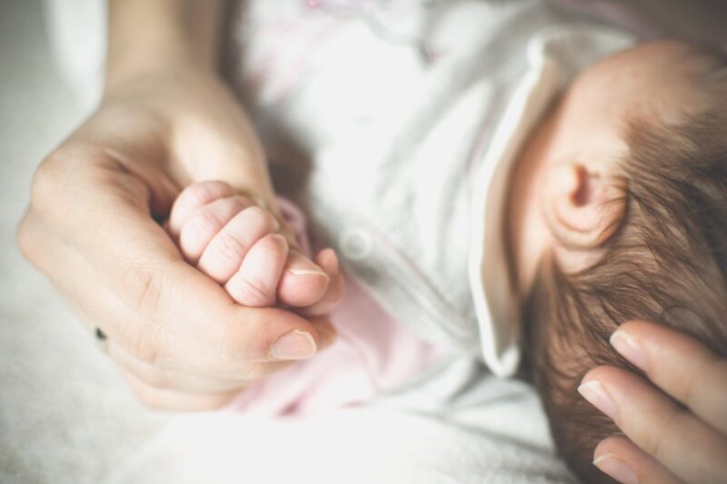 Hình ảnh mẹ ru con ngủ nắm chặt tay