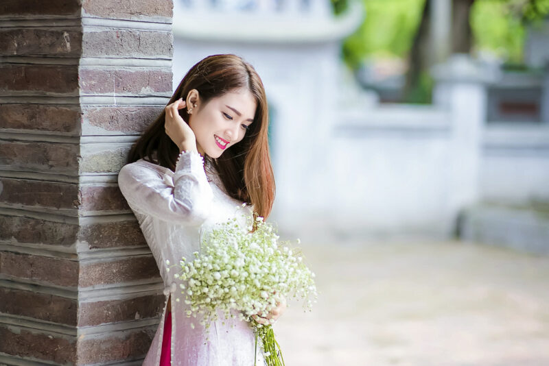 Hình cô gái cầm hoa mặc áo dài