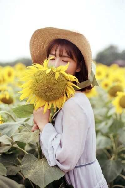Hình cô gái cầm hoa màu vàng