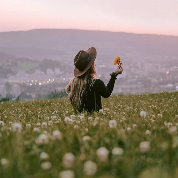 Hình cô gái cầm hoa trong cánh đồng