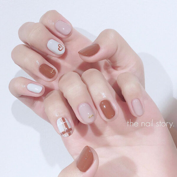 Milchweißes Nagelmodell mit brauner Farbe