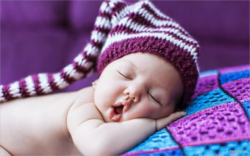 Schläfriges Foto von Baby mit lila Mütze