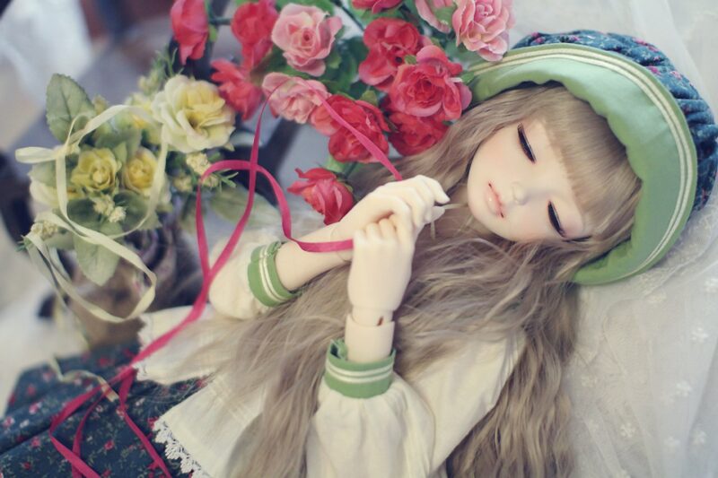 Ảnh búp bê dễ thương bên những đóa hoa