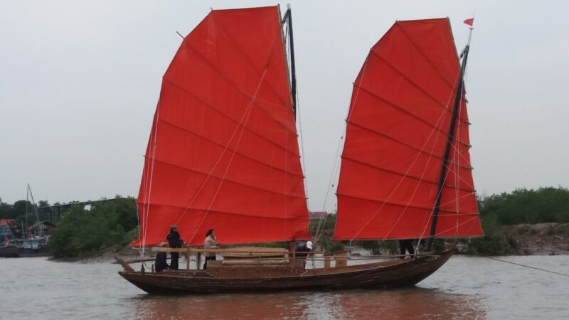 Ảnh thuyền buồm đỏ trên mặt nước phẳng lặng