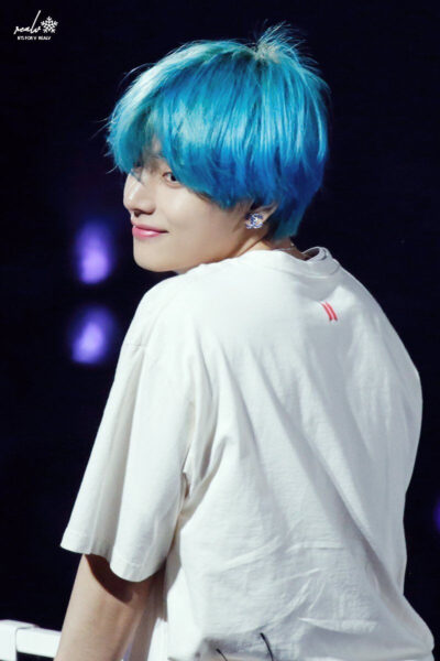 Ảnh V tóc xanh cười nhẹ